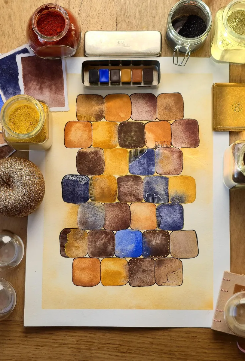 Boîte d'infirmière ancienne garnie de 6 aquarelles, posée sur une peinture de carrés aux ocres et aux bleus