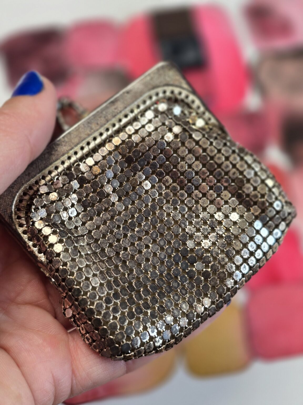 Ancien porte-monnaie en maille métallique tenu en main, détail de la maille argentée – Madame Pigmentum