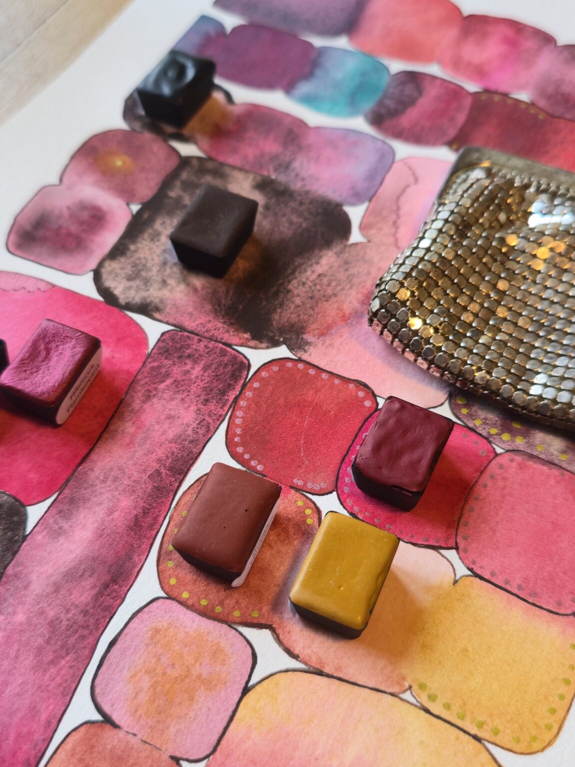 Demi-godets d'aquarelles artisanales aux tons terre et rose près de l'ancien porte-monnaie en maille métallique – Madame Pigmentum